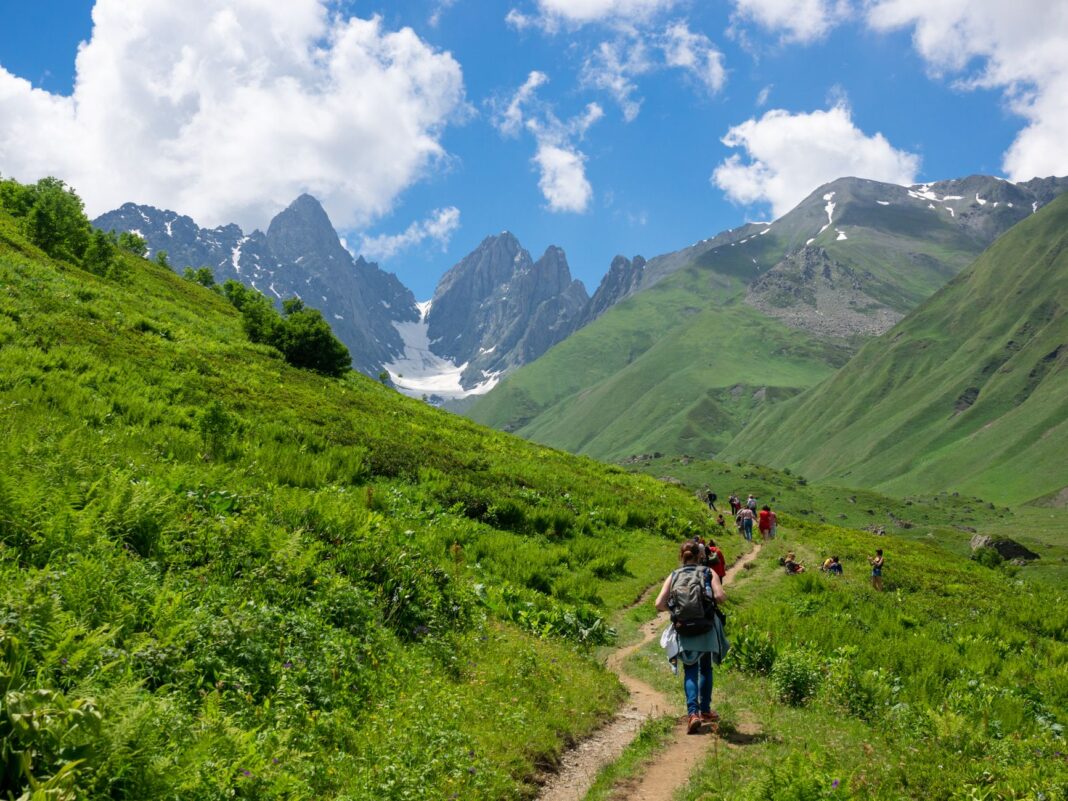 Turyści na górskim szlaku w kaukaskich górach Gruzji