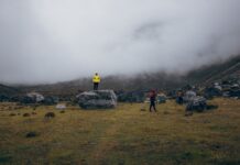 Turyści na mglistych trawiastych zboczach w rejonie Gauri Sankar w Nepalu