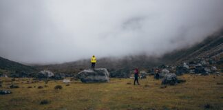 Turyści na mglistych trawiastych zboczach w rejonie Gauri Sankar w Nepalu