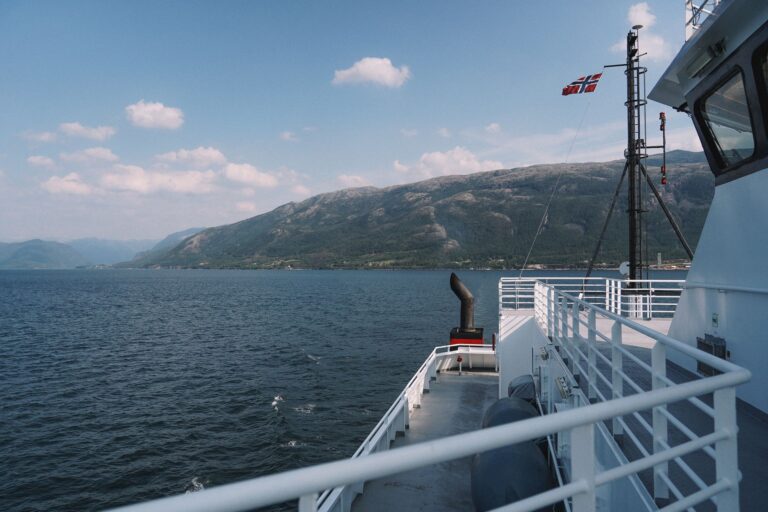 Widok na norweski fiord z pokładu promu pod bezchmurnym niebem